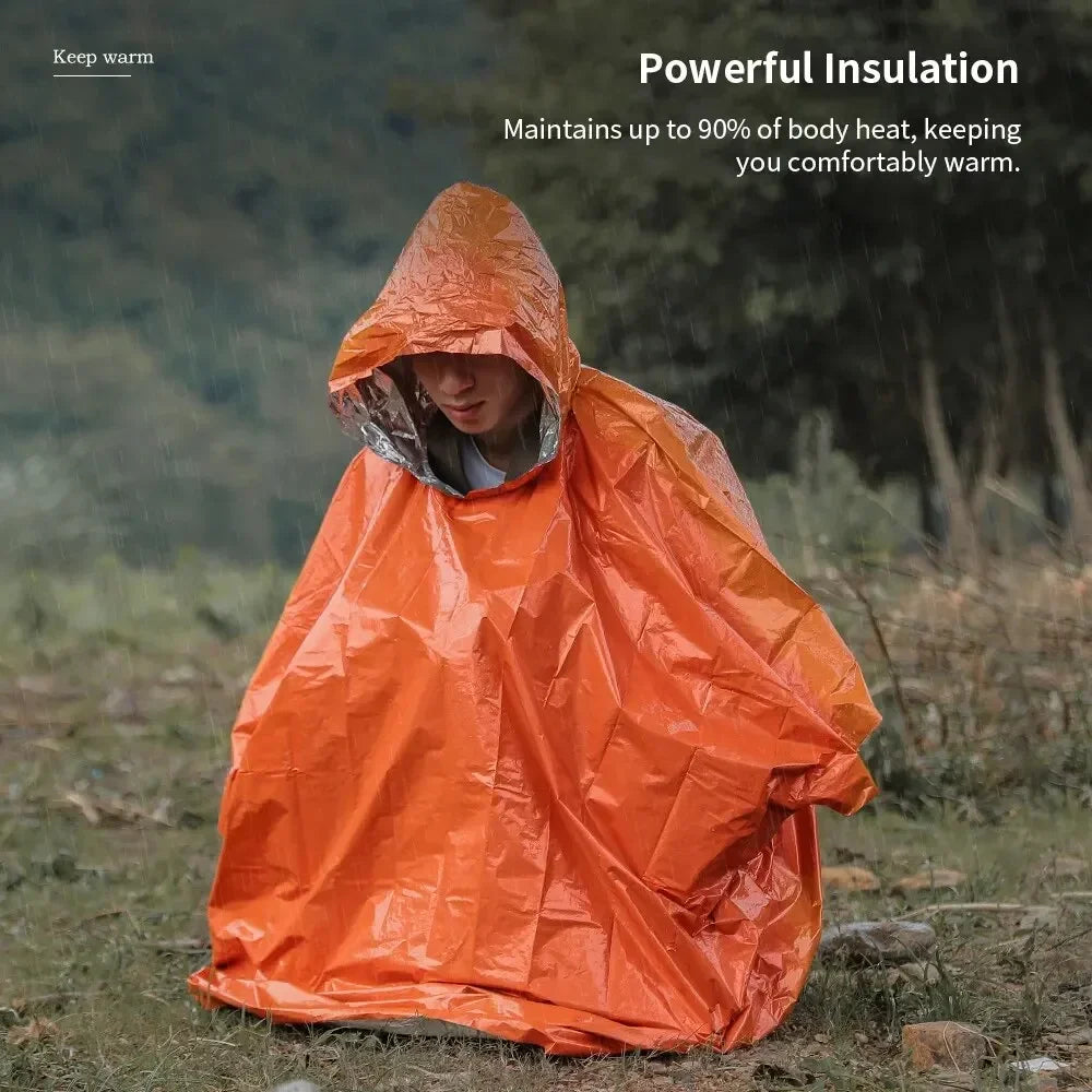 Person wearing an orange insulation blanket in a forest setting